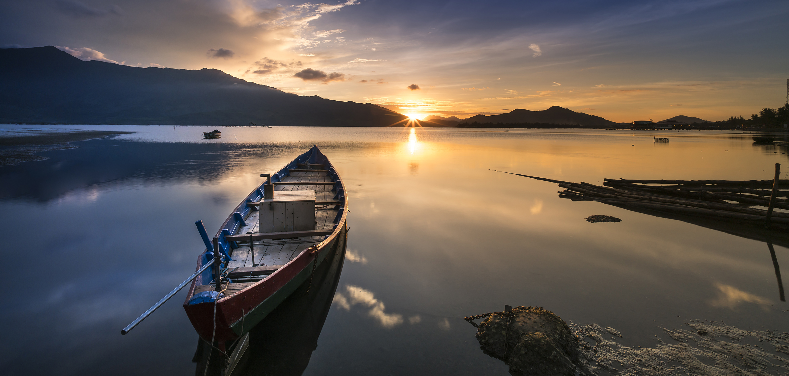 Boot auf dem Wasser mit aufgehender Sonne